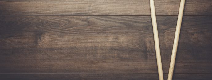 Pair of drumsticks on wooden background.