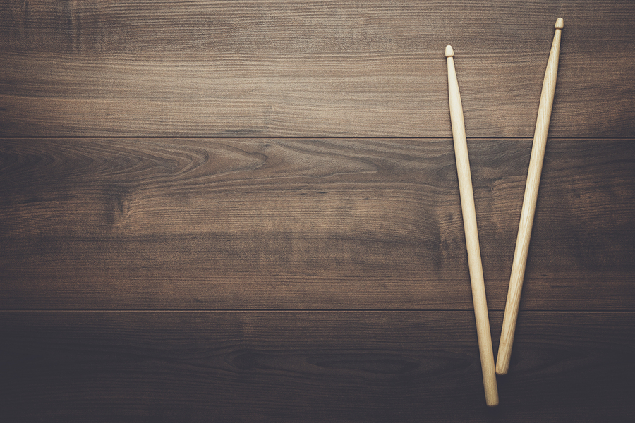 Pair of drumsticks on wooden background.