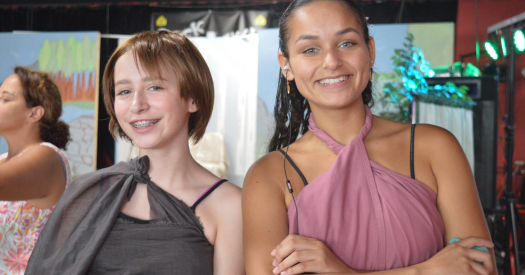 Two DeAngelis stundents in stage costume smiling at camera.